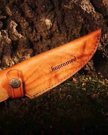 Skórzana pochwa noża myśliwskiego Kopromed na tle kory drzewa. Przejdź do oferty akcesoriów do noży. Skórzana pochwa noża myśliwskiego Kopromed na tle kory drzewa. Przejdź do oferty akcesoriów do noży.