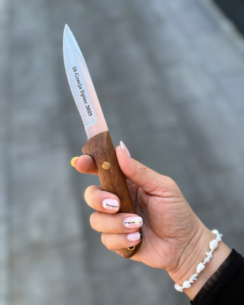 Osoba trzymająca nóż z grawerem. Przejdź do strony o personalizacji.